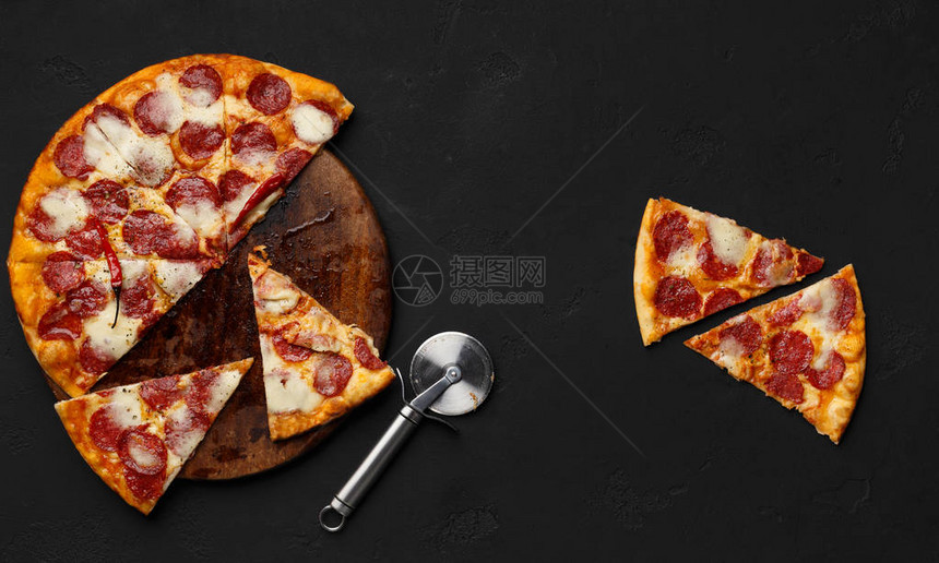 剪切的辣椒尼披萨在切割板上切开薄饼与切刀附图片