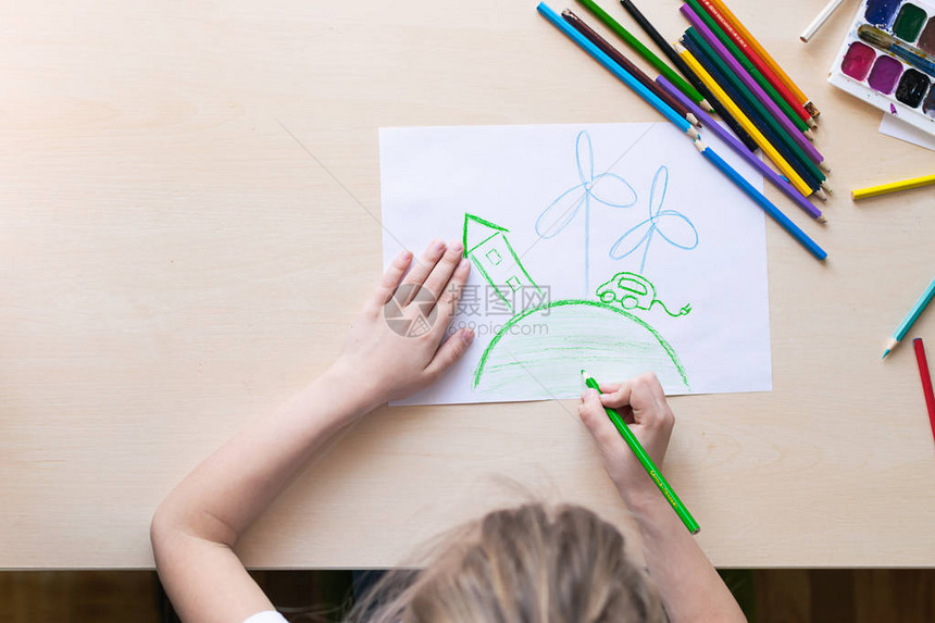 一个小女孩用彩色铅笔画出温室电动汽车和风力发电站生态和环境保护的概念从上面查看复制空图片