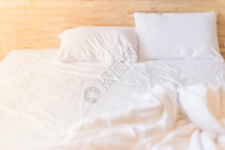 模糊早晨白色干净凌乱的床为背景图片