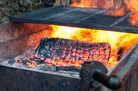 烧烤炉中烧柴的亮火在烤肉之前图片