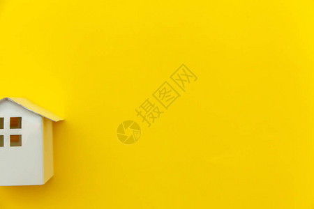 简单的最小设计与微型白色玩具屋隔离在黄色多彩时尚现代时尚背景抵押财产保险梦想家园概念平躺顶背景图片