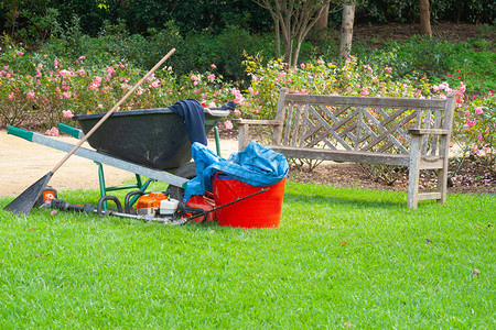 园丁的设备留在草坪上在木凳椅座位旁图片