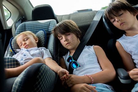 疲累的孩子在旅行时睡在汽车里图片