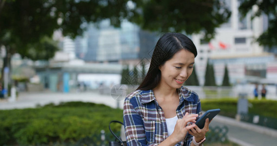 女人在城市看智能手机图片