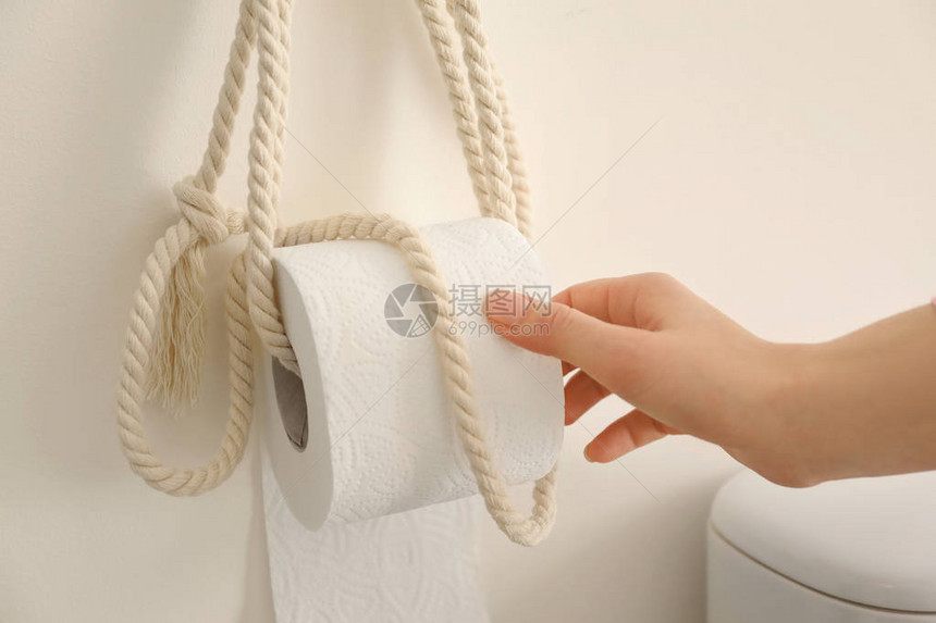 年轻女子在洗手间拿软卫生纸图片