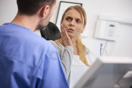 牙痛的女人和牙医说话图片