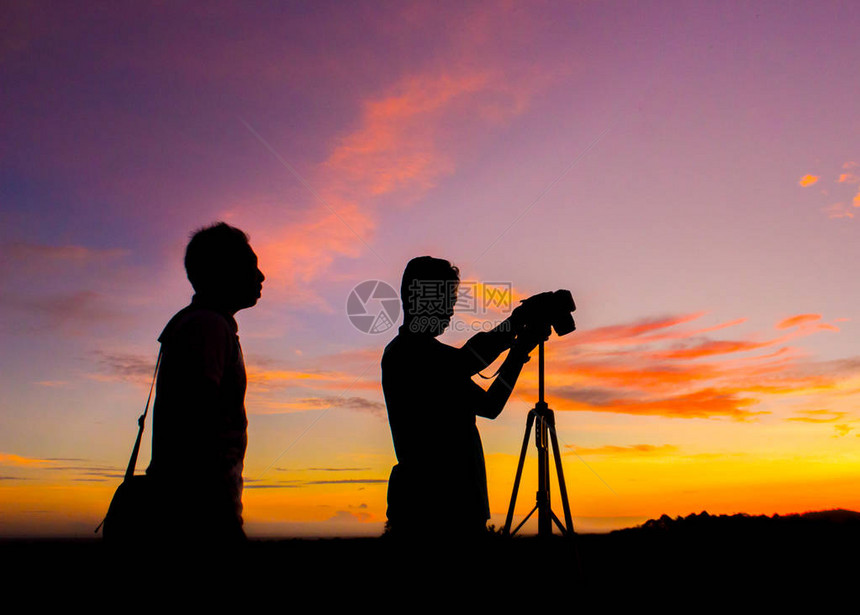 siluet两位摄影师在日落时刻图片