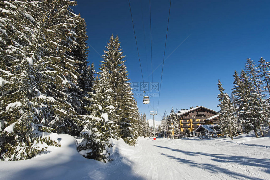 在高山度假胜地用有电缆的汽车电梯和旅馆遮盖雪滑雪活塞图片