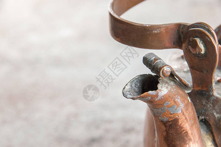 古董铜水壶紧贴在混凝土背景上图片
