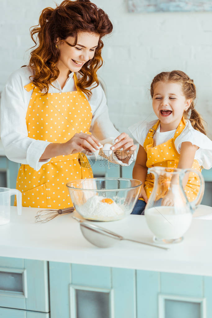 快乐的母亲和女儿在厨房一起做饭时图片