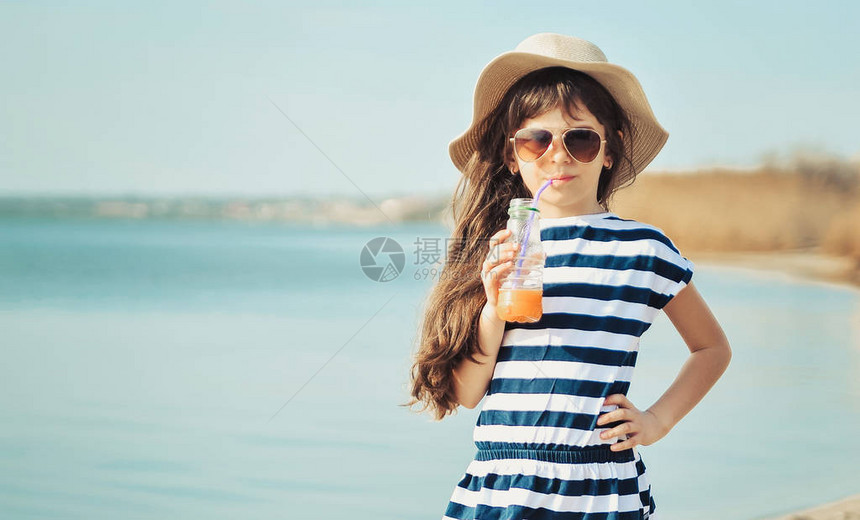 戴着帽子的小女孩在海滩上散图片
