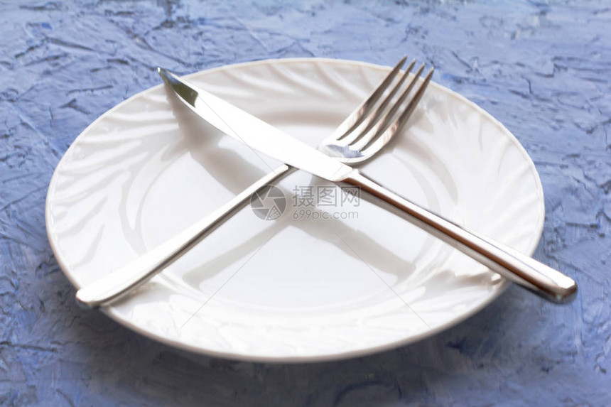空的白色盘子叉子和刀子在桌上图片