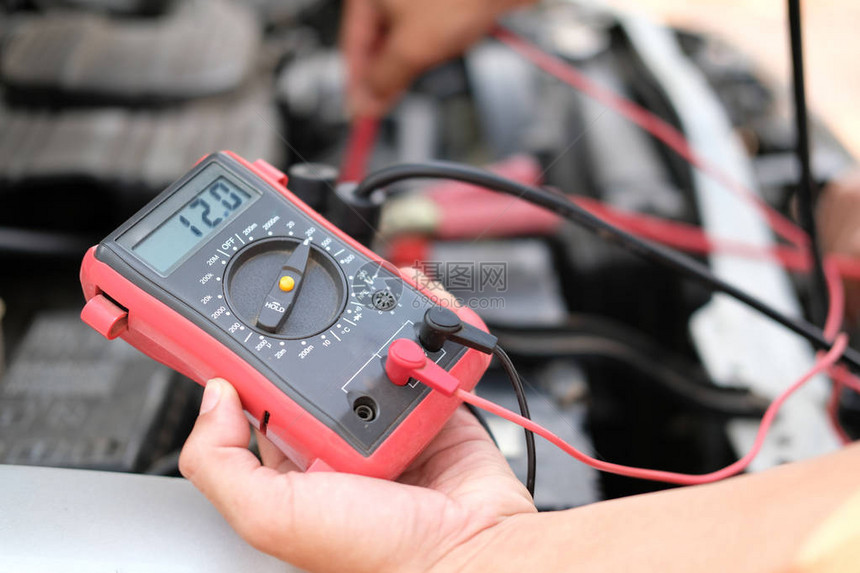 在修理服务站用电压计多米检查汽车电池压图片