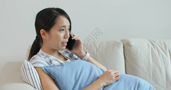 女人在家里打电话坐在沙发上图片