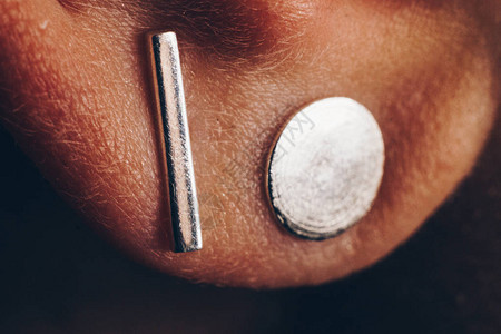 耳朵特写的银首饰金属耳环宏概念极简主义白图片