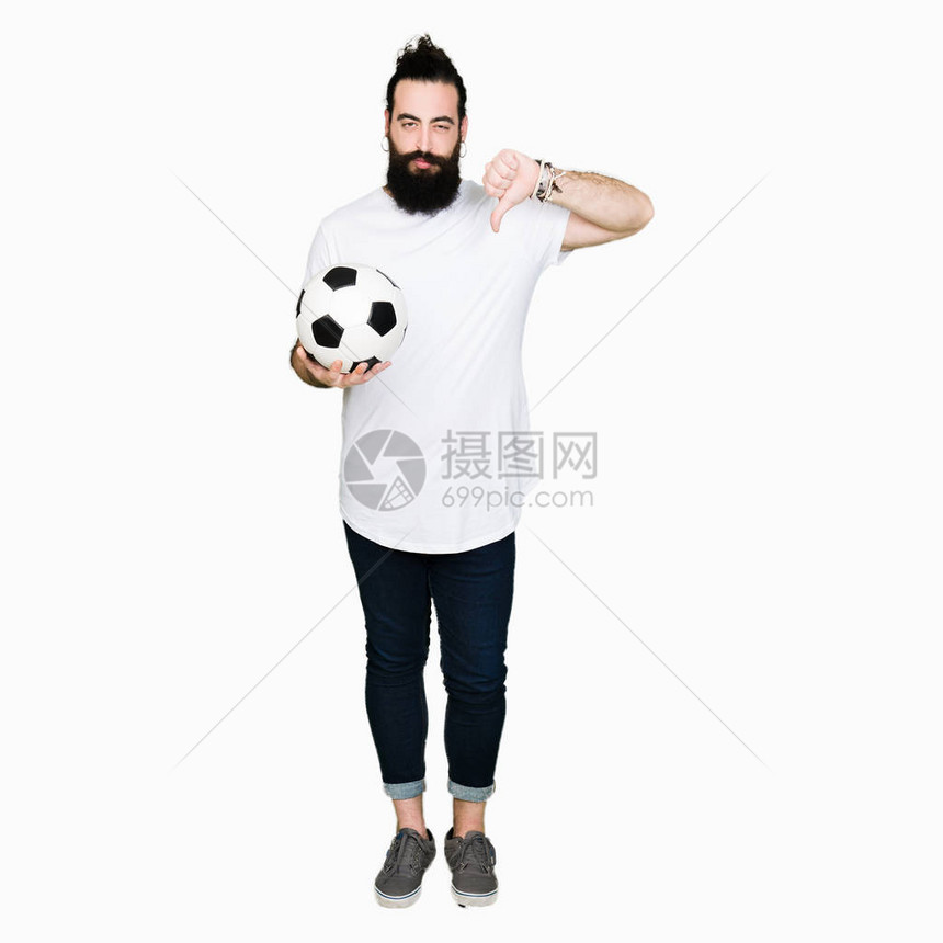 长头发和熊的年轻人带着愤怒的脸拿着足球图片