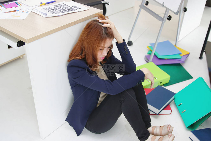 愤怒的亚洲年轻女商人在办公室工作时坐在地板上头顶着图片