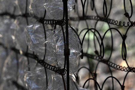金属生锈的网格上有许多塑料瓶图片