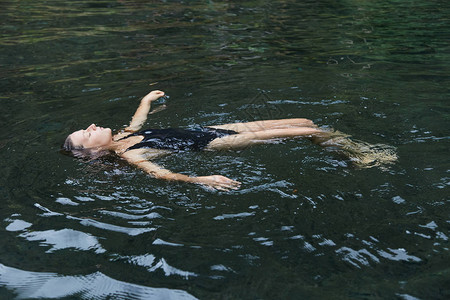这个女孩在天然水池里游泳爪哇岛一个年轻的女孩在游泳池里游泳体内图片
