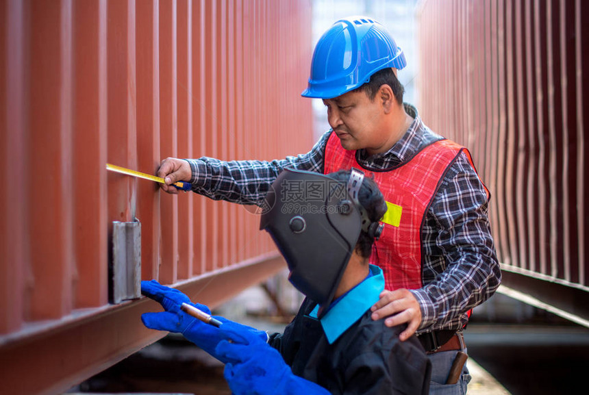 亚洲工程师检查和测量维修部件并监督他的工人进行焊接工作图片