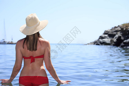 旅行职业假期概念戴帽子的女人躺在海边沙滩上的躺椅上暑假期的女孩图片