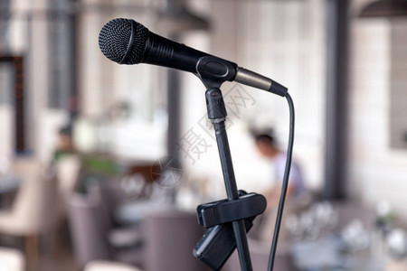 餐厅大舞台背景上的特写黑色铁麦克风为宴会服务晚上在酒吧举行概念现场音乐会餐饮自助餐周年纪念背景图片