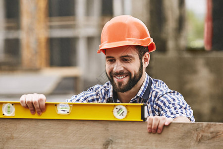 快乐的建筑工人戴着黄色防护头盔图片