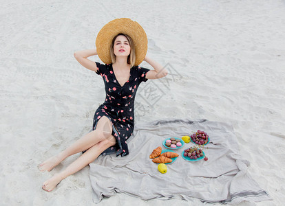 美丽的女人在海边的沙滩上休图片