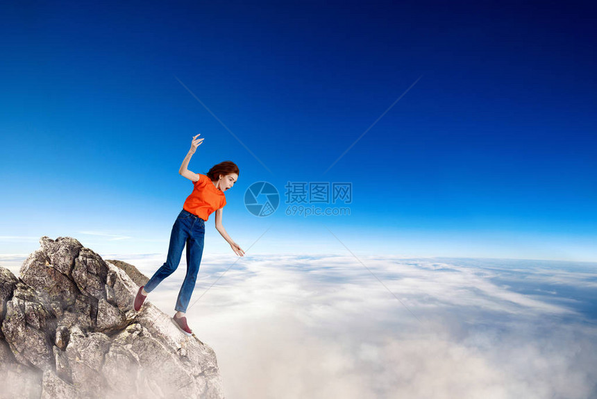 年轻女子在岩石上跌倒坠图片