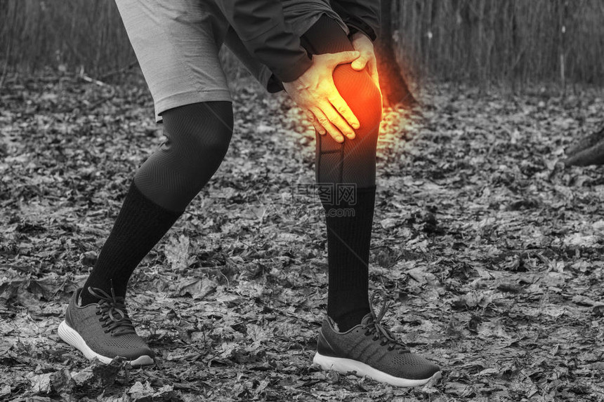 一名穿着训练服的男子在户外锻炼时慢跑时膝盖受伤损伤跑步技术错误跑步肌腱炎图片