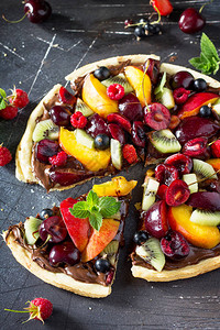 美味自制的夏天水果莓披萨和巧克力糊贴在黑石桌图片