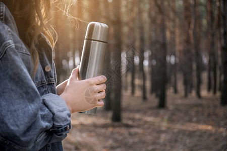 森林里拿着热水瓶的女人图片