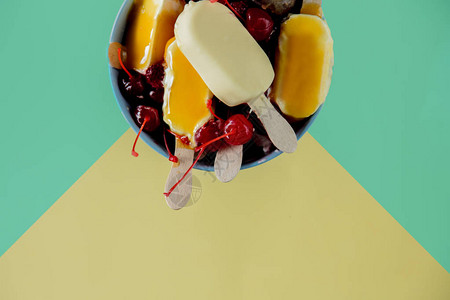 柠檬和巧克力冰棒蓝黄背景的草莓和樱桃图片