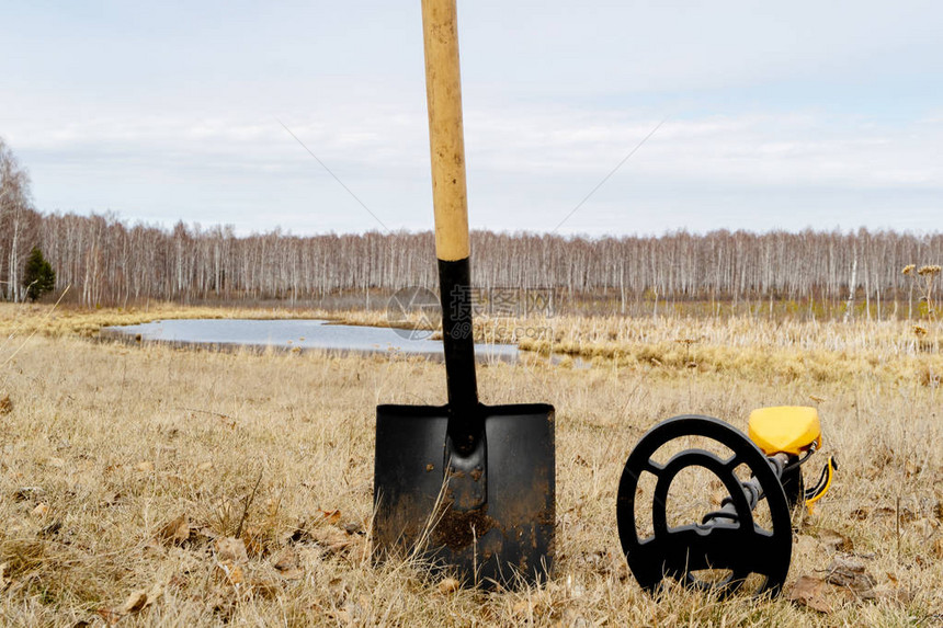 金属探测器和铁锹卡在地上金属搜索设备田间干草背图片