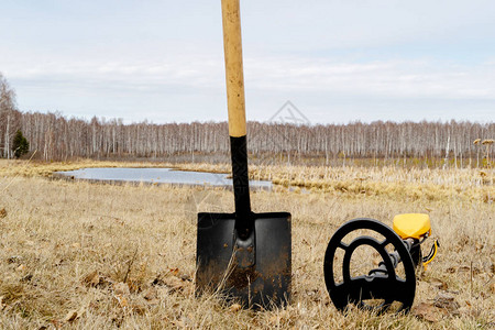 金属探测器和铁锹卡在地上金属搜索设备田间干草背图片