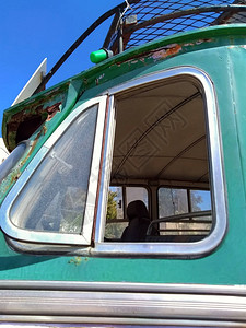 关闭一辆旧绿色生锈的老式巴士的侧窗图片