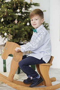 一个可爱的小男孩的画像圣诞装饰品中的小男孩骑着摇摆鹿的男孩子们骑着图片