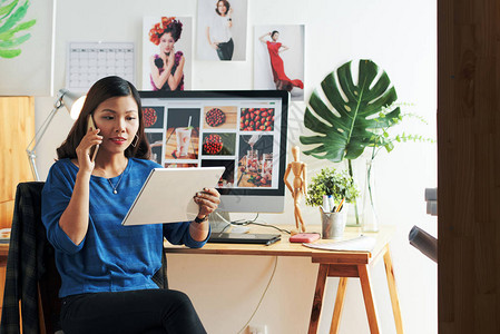 越南女设计师在数字桌子上看照片图片