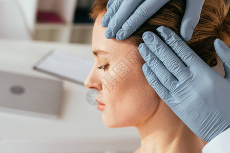 用乳胶手套检查诊所有吸引力病人毛发的皮肤科医图片