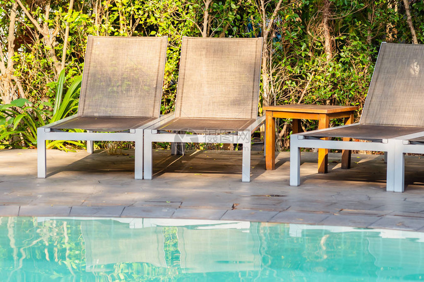 在旅馆度假村游泳池周围的空椅子图片