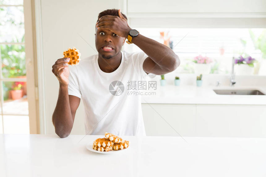 非洲裔美国人吃甜比利时华夫饼时用手顶着头强调图片