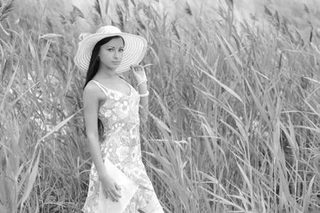 穿着白色连衣裙和夏季帽子的年轻女子图片