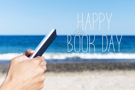 在海滩上读一本书和文本快乐的书日图片