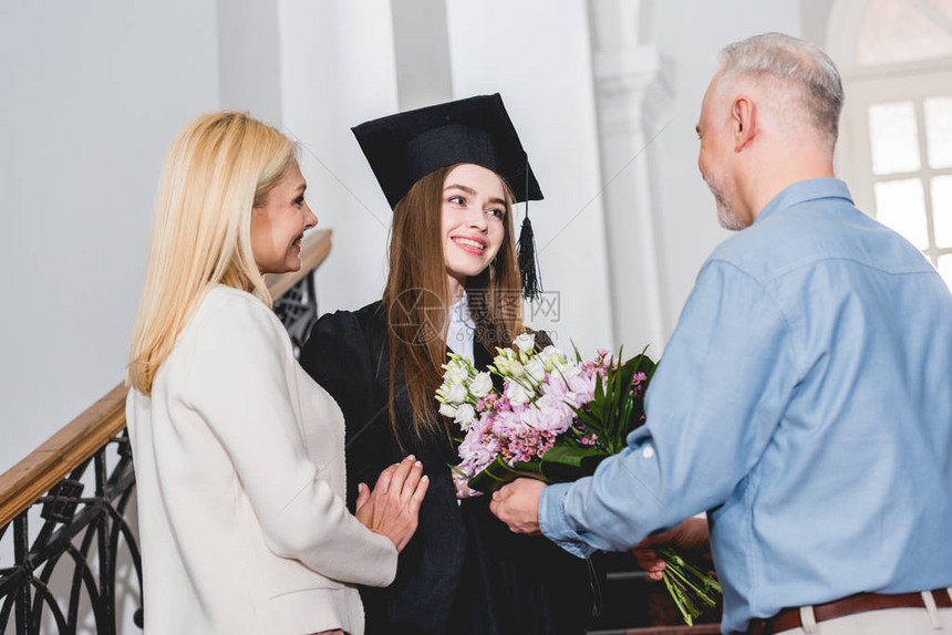 快乐的父亲给快乐的女儿送鲜花在毕业上限图片
