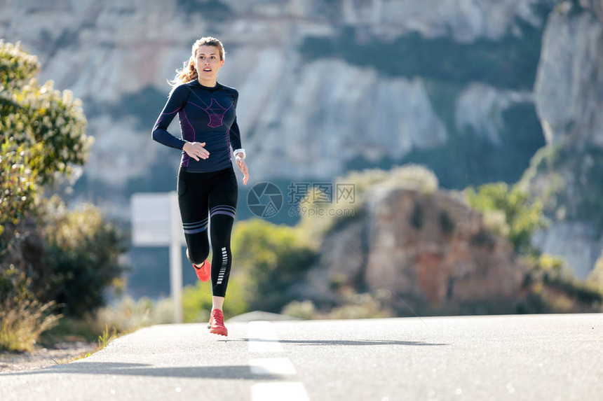 在山路上跑着的年轻运动女子美丽图片