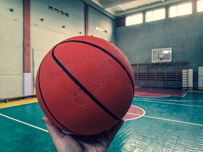 篮球篮球场手拿着球背景图片