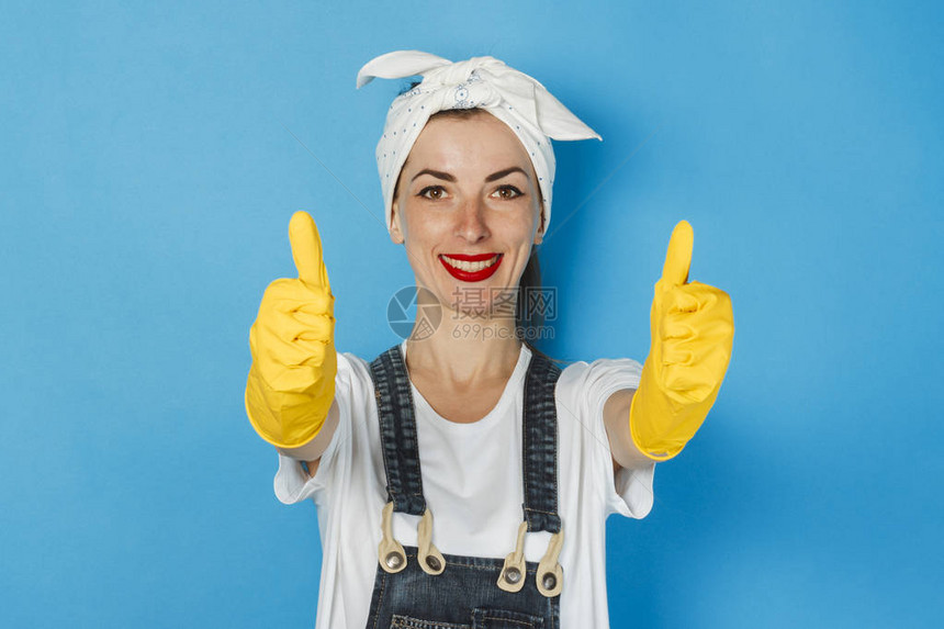 头戴围巾和黄色橡胶手套的年轻女孩竖起大拇指图片