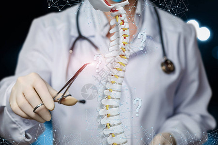医生用听诊器操作人体骨骼人工脊柱模型的特写镜头图片