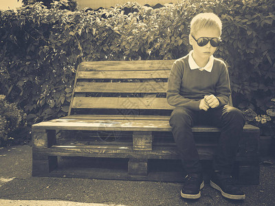 时尚男孩坐在木凳上图片