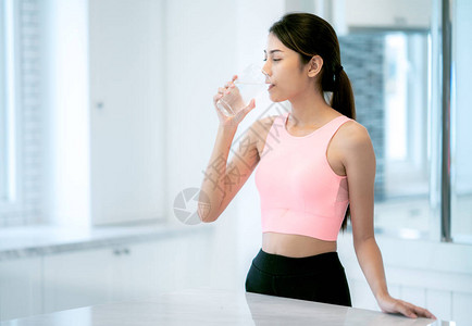 亚洲女士在客厅健身和锻炼后喝水图片